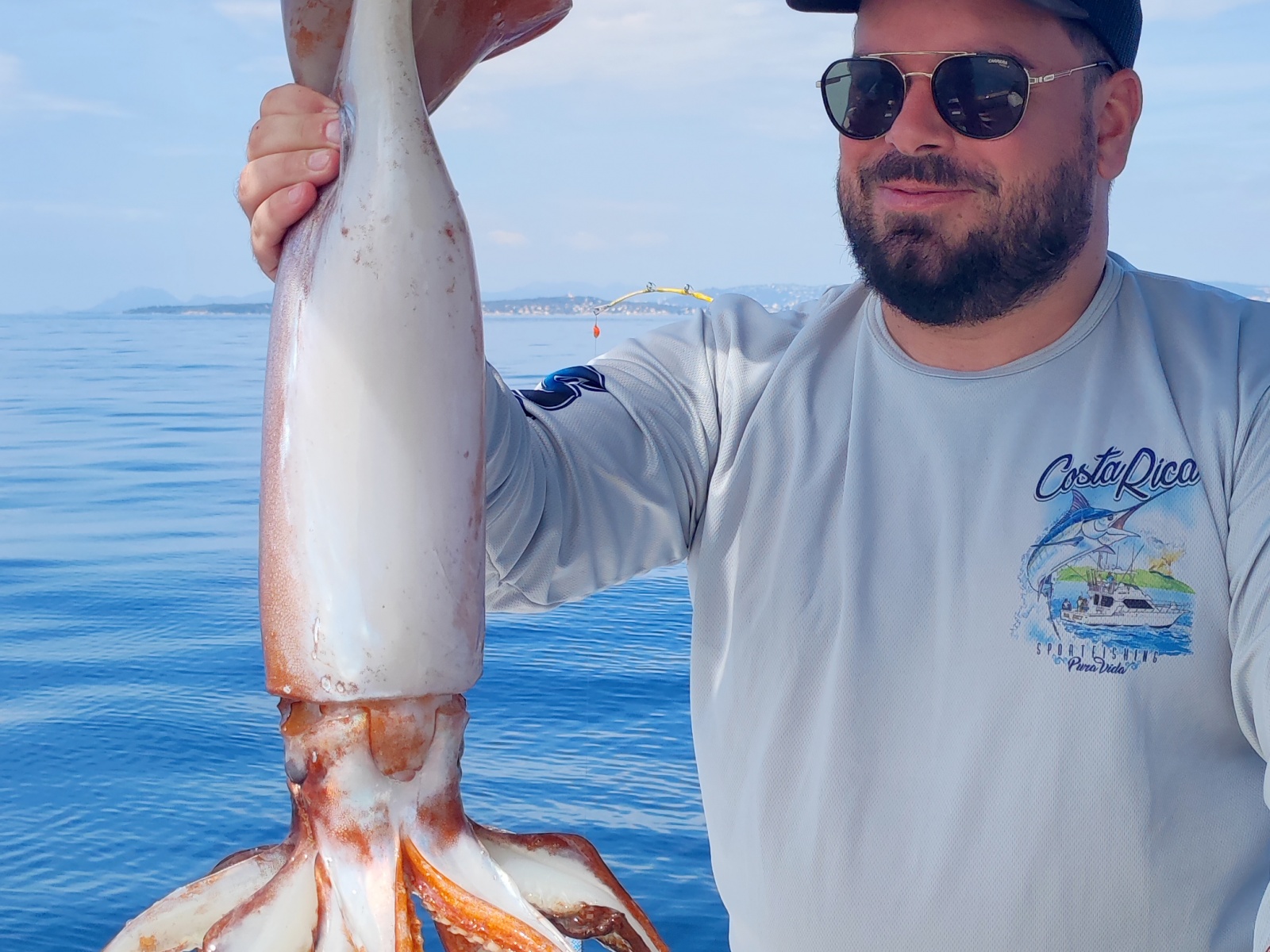 Un des stagiaires du guide de pêche Fabien Harbers avec un énorme calamar rouge pris à la turlutte-appâts !