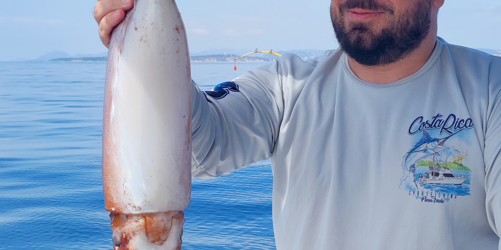 Un des stagiaires du guide de pêche Fabien Harbers avec un énorme calamar rouge pris à la turlutte-appâts !